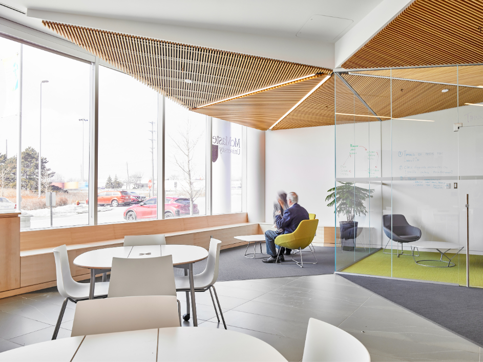 Two professionals speaking in an office lobby.